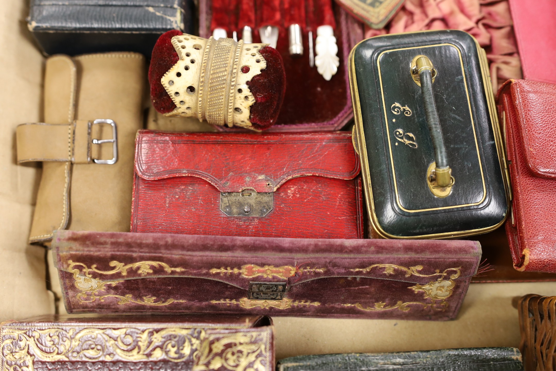 A large collection of mostly late 19th, early 20th century Morocco leather Etui a carved bone pin cushion and two miniature baskets. Largest basket 18cms wide